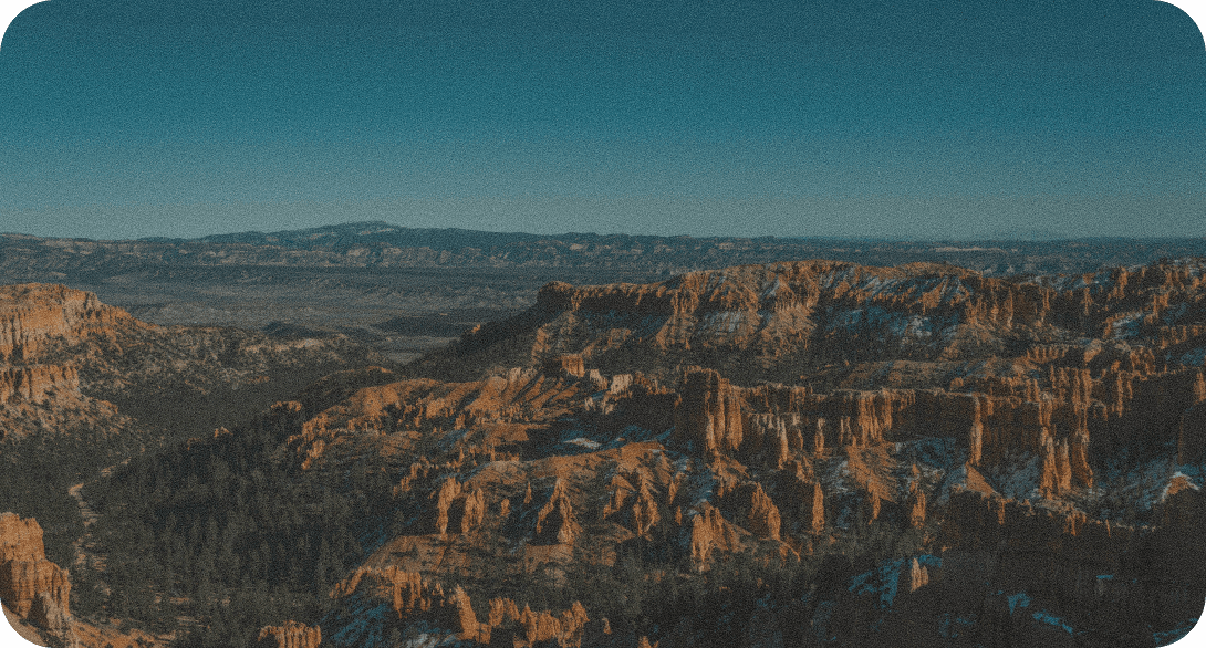 A wide canyon landscape under a clear blue sky
